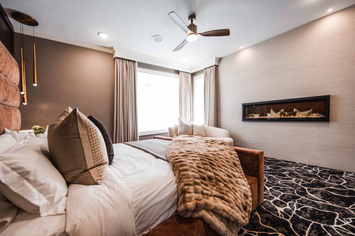 Luxury primary suite bedroom remodel with fireplace wall feature— The Ember Suite by Discrete Designs."