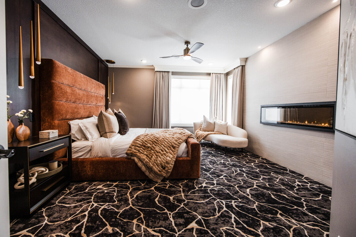 Luxury primary suite bedroom remodel with rust velvet channel-tufted bed and walnut paneled feature wall in central minnesota