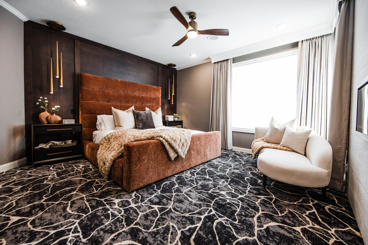Luxury primary suite bedroom remodel with rust velvet channel-tufted bed and walnut paneled feature wall — The Ember Suite by Discrete Designs."