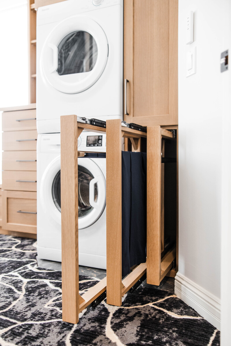 Custom primary bedroom walk in closet with washer and dryer and pull out drying racks