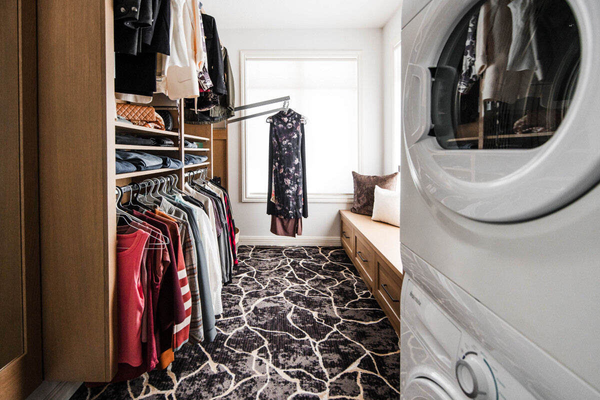 Custom primary bedroom walk in closet with pull down clothing racks for easy access. 